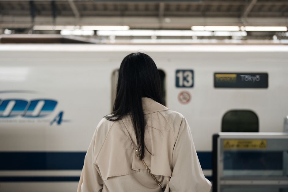 新幹線のホームで電車を待つ人。帰省の道中