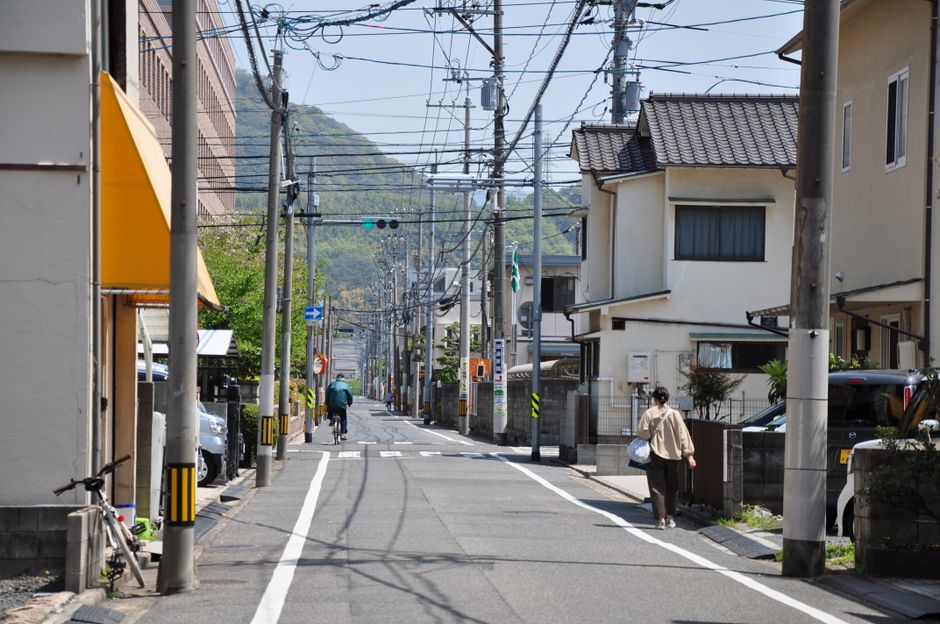 日本の住宅街の道を歩く人。連休のあいだも一日一度は外に出る